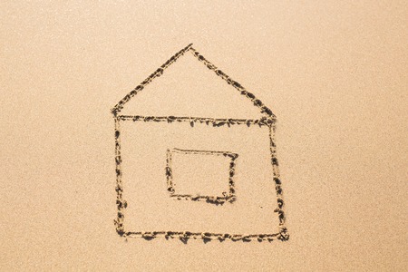 house on the beach. house painted on sandの写真素材