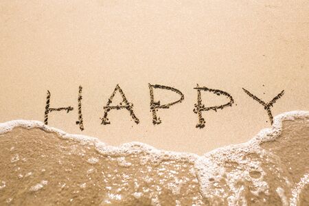written words Happy on sand of beach.の写真素材