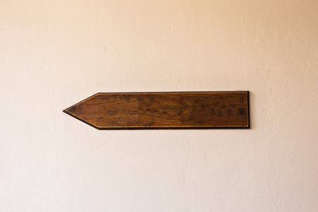 Pointer wooden plank on the background of a wall