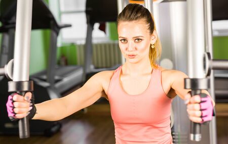Athletic young woman doing a fitness workout with training apparatus in a fitness club