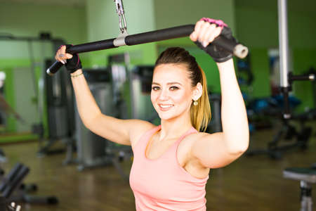 Athletic young woman doing a fitness workout with training apparatus in a fitness club