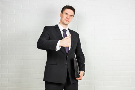 business and office concept - handsome buisnessman showing thumbs up.
