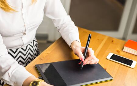 Woman hand drawing with graphics tablet, working designer.の写真素材