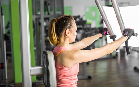 Young woman weight training at the gym.