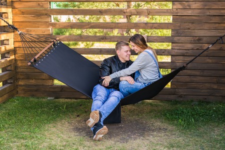 Expectant young loving couple on hammock outdoorsの写真素材