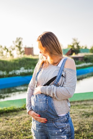 young happy pregnant woman relaxing and enjoying life in autumn nature.の写真素材