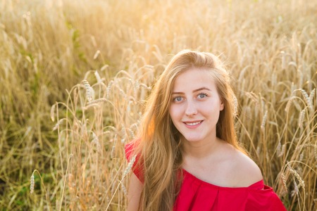 Beautiful lady in wheat field at sunset.の写真素材