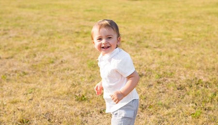 Little boy on the street, in the countryside. Toddler playing active games outdoors. Childhood, carefree, children's games, boy, fresh air, active children's rest. The concept of childhoodの写真素材