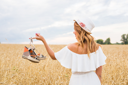 Young woman holding a shoe - sale, consumerism and people concept.の写真素材