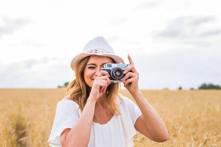 female photographer in the field with a camera taking pictures.の写真素材