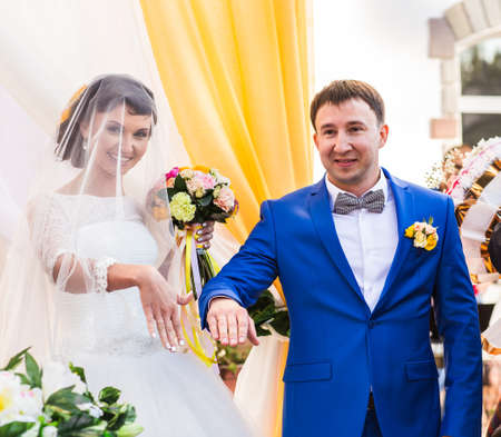 Stylish happy smiling newlyweds on the luxury outdoor wedding ceremony.の写真素材