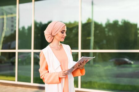 muslim business woman smiling while holding her fileの写真素材