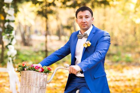 Beautiful groom wedding portrait with white bikeの写真素材
