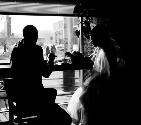 Silhouette of bride and groom in cafe.の写真素材