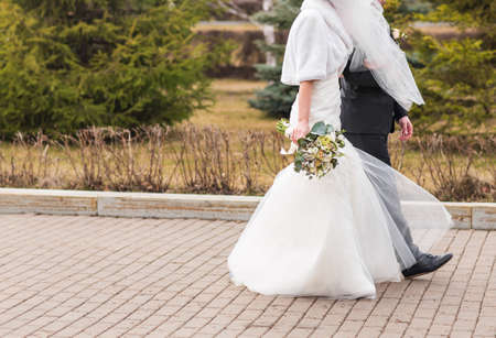 happy bride and groom walking in the autumn forestの写真素材