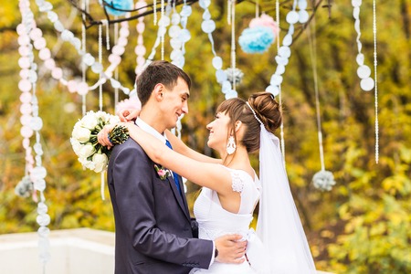 Groom and Bride in a park. wedding dress. Bridal wedding bouquet of flowersの写真素材