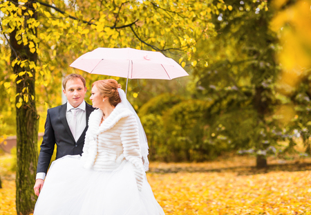 bride and groom standing under an umbrellaの写真素材