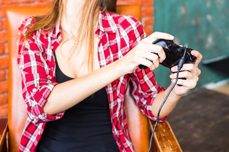3d technology, virtual reality, gaming, entertainment and people concept - happy young woman in virtual reality headset or 3d glasses and headphones playing video game with controller gamepad at homeの写真素材
