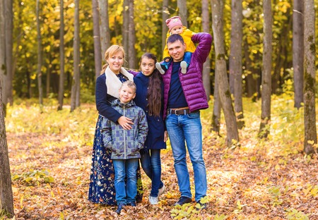 Happy family having fun outdoors in autumn park.の写真素材