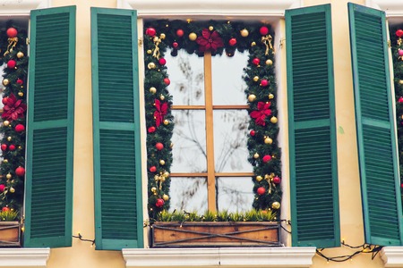Christmas Red ball decorated windows on vintage house.