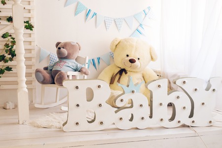 White bedroom with blue decorations designed and teddy bear ideal for both boys and girls.の写真素材