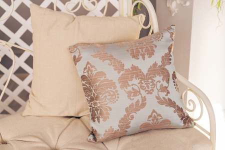 Stylish white armchair or sofa with pillows