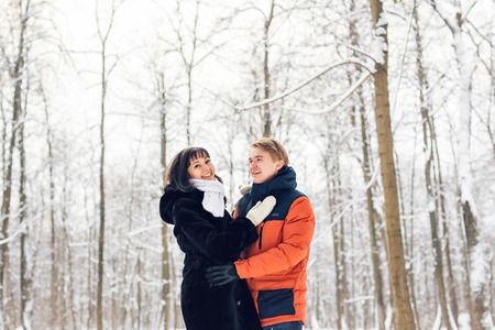 Young couple in love walking in the snowy forest.の写真素材