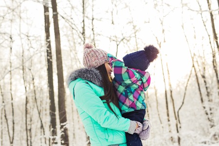 Portrait of happy mother and baby in winter parkの写真素材