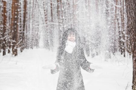 Girl playing with snow in park. Woman in winterの写真素材