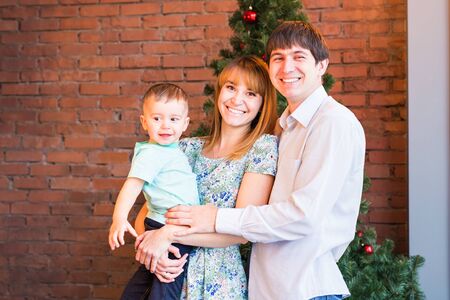 family, christmas, x-mas, winter, happiness and people concept - smiling family and christmas tree.の写真素材