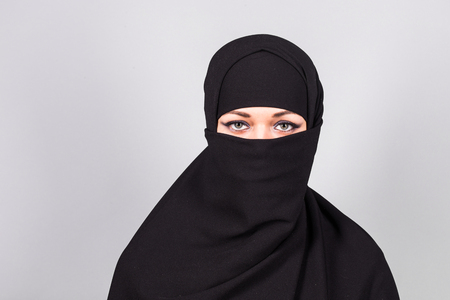 Young woman wearing black niqab on background.の写真素材