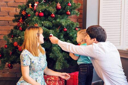 christmas, x-mas, family, people, happiness concept - happy parents playing with pretty baby boyの写真素材