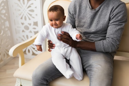 Happy African American Father Holding Smiling Baby Boy.の写真素材