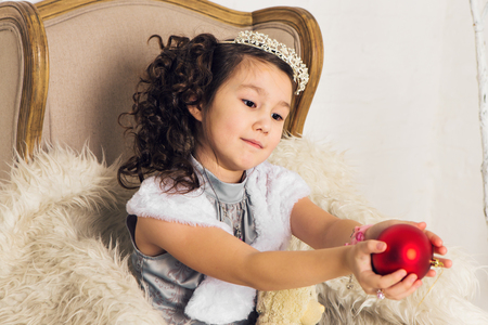 Girl holding christmas red ball to decorate christmas tree.の写真素材
