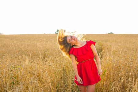 Gorgeous Romantic Girl Outdoors. Beautiful Model in Short Dress in Field. Long Hair Blowing in the...
