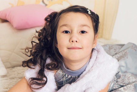 Portrait of adorable asian girl relaxing on the bedの写真素材