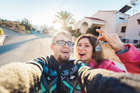Happy smiling young couple showing a keys of their new houseの写真素材