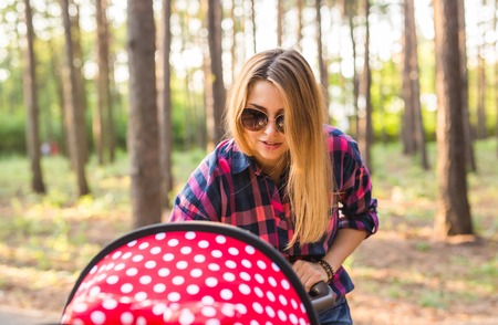 Closeup of mother with baby in pram walking in summer parkの写真素材