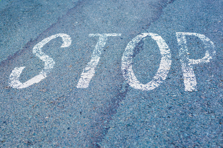 Word Stop written on an asphalt road, Top view on the road in perspective.の写真素材