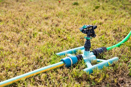 Sprinkler head for spraying water over green grass.の写真素材