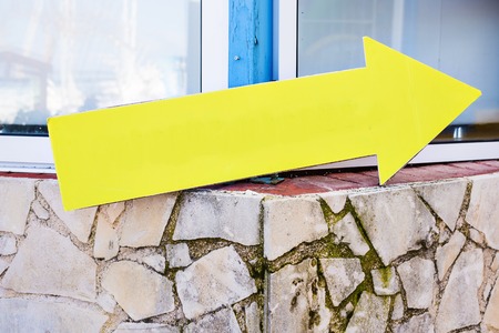 Yellow plastic informational sign arrow. Show the direction. Blank Sign post. Abstract yellow arrow direction signの写真素材