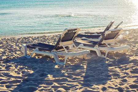 Sunbeds on the sea beach during sunset.の写真素材