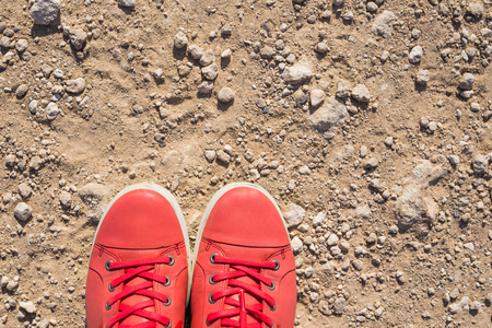 Feet in casual pink shoes on the stone backgroundの写真素材