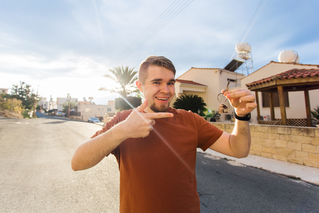 Concept of housewarming, real estate, new home - Young man holding key of new house.の写真素材