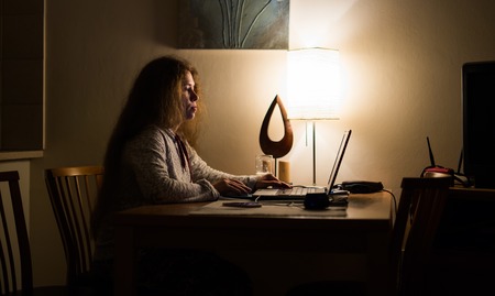 Woman working with laptop computer at night