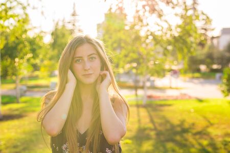 Portrait Of Young Beautiful Woman. Close-up portrait of a fresh and beautiful young fashion model posing outdoor. Summer outdoor portraitの写真素材
