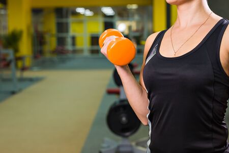Closeup on fitness woman workout with orange dumbbell.の写真素材