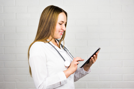 Smiling doctor using a tablet computerの写真素材