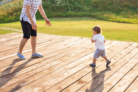 Happy laughing little boy playing in nature with fatherの写真素材