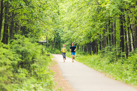Running together - friends jogging in parkの写真素材